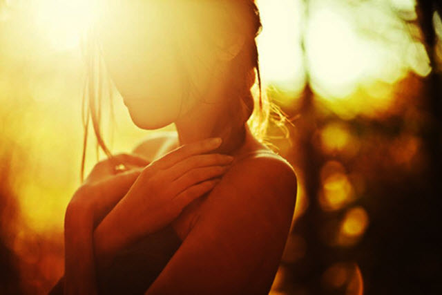 girl in sunlight with hands across her heart
